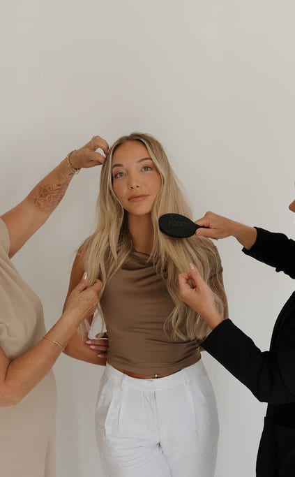 Jordan and Michelle working on a model's hair from either side